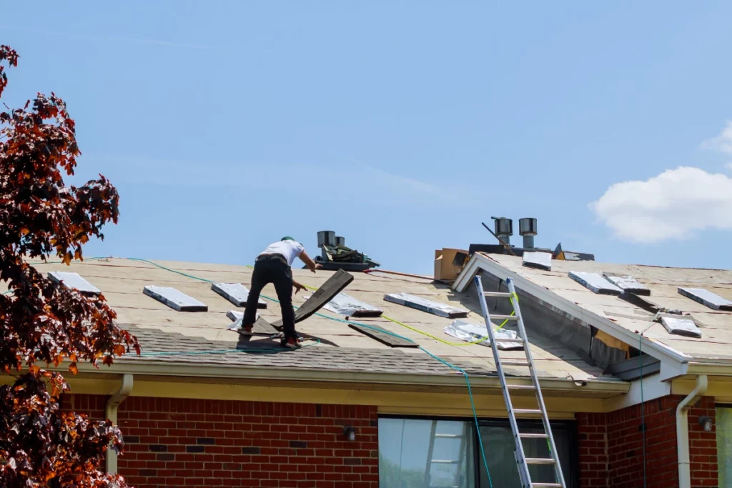 A man is diligently working on a roof in Lakeland, displaying focus and determination as he strives to complete the task at hand.