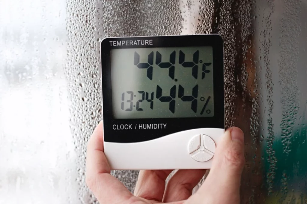 Measurement of air temperature, dew point, humidity with a device (hygrometer), against window with condensation